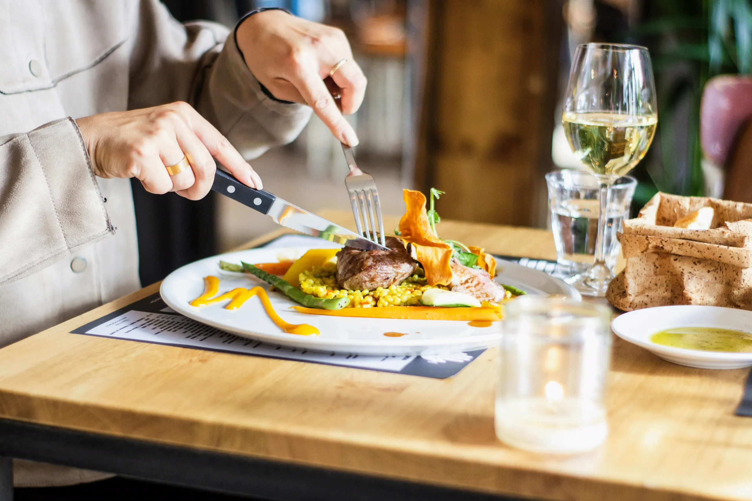 Una mesa con la comida servida y una copa de vino